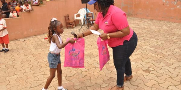 Une élève reçoit un cadeau lors d'une cérémonie dans la cour